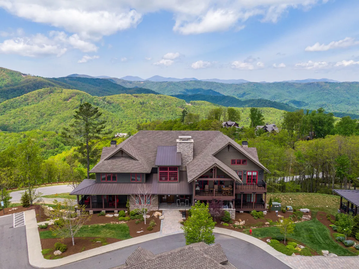 A peaceful exterior view of the property with mountain vistas, architectural details of the building, and a landscaped garden. The scene is calm and rejuvenating, ideal for relaxation or contemplation between wellness activities.